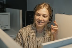 Une femme en blazer à carreaux marron et blanc portant des écouteurs noirs